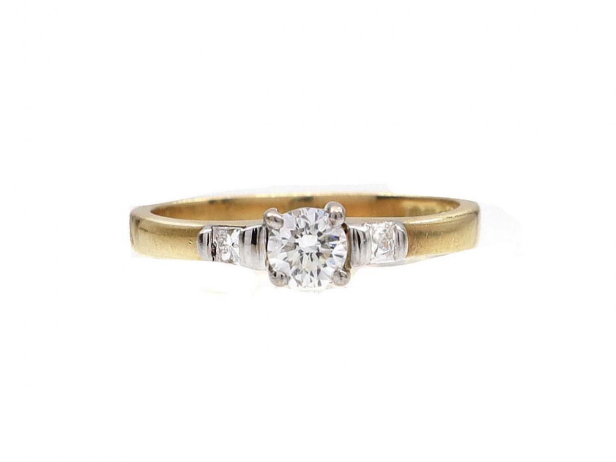 Flanked diamond solitaire engagement ring in 18kt yellow gold